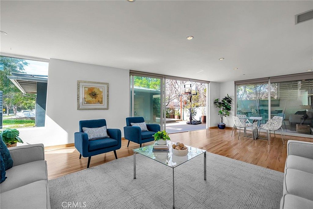 Great room with wall of sliding glass opening to the backyard and mature trees.