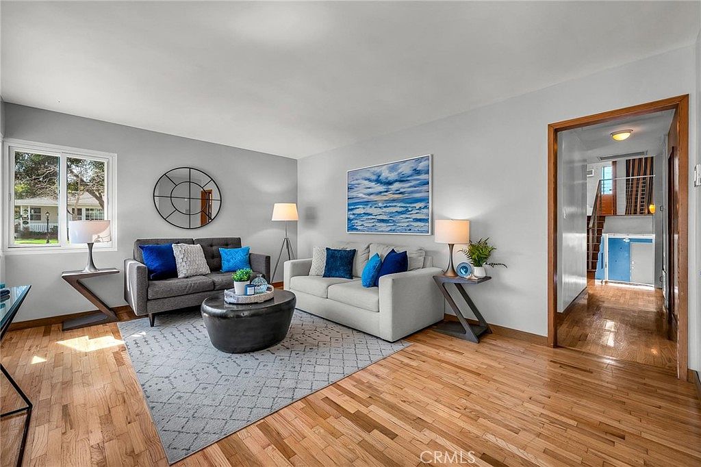 Main living room with gallery wall and warm hardwood flooring.