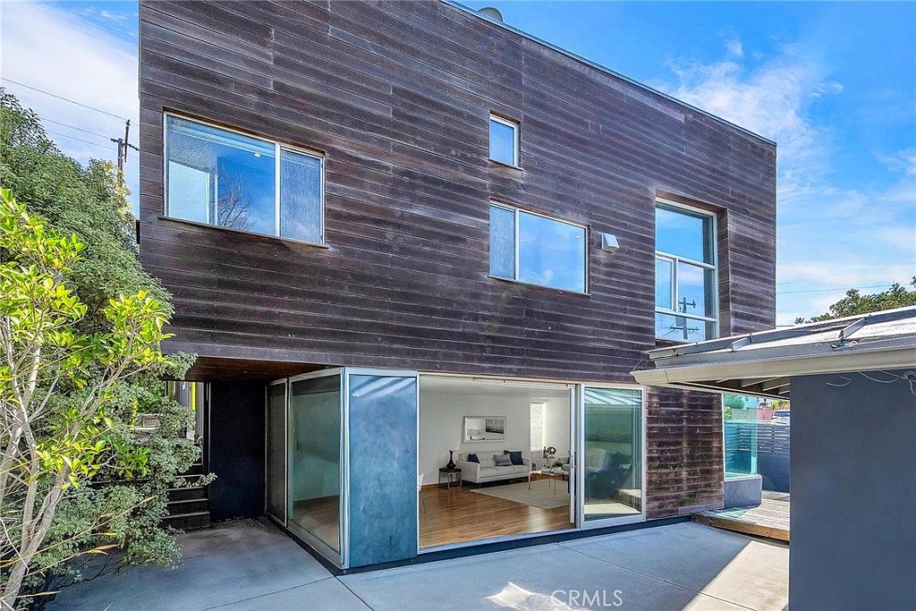 Rear elevation showing the full cedar-clad volume and clerestory windows.