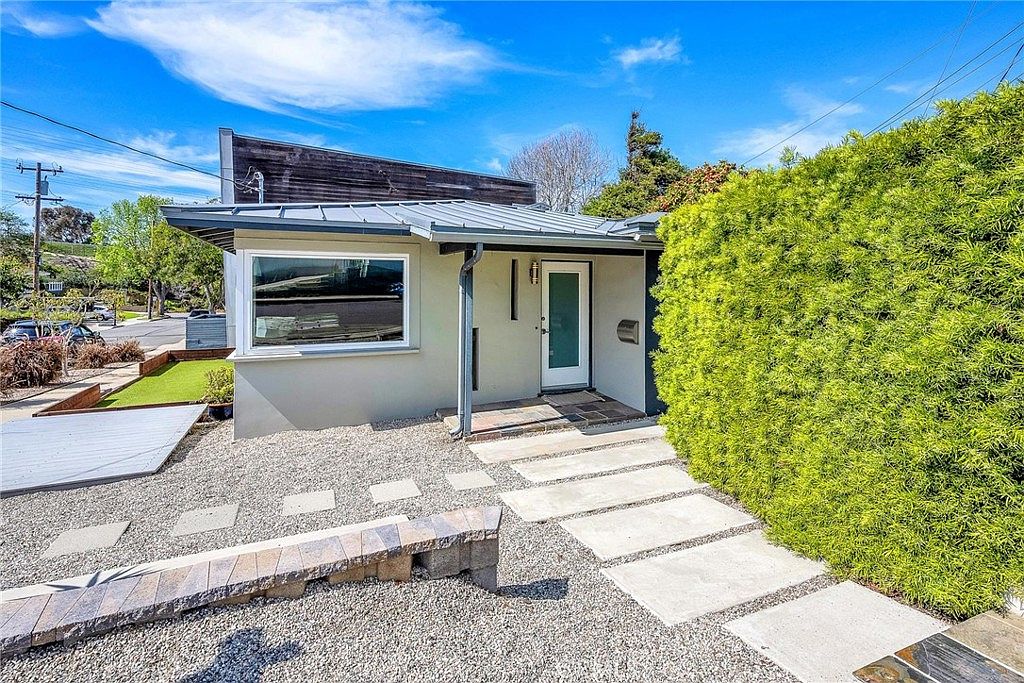 Front entry of the original 1952 ranch with hedged path.